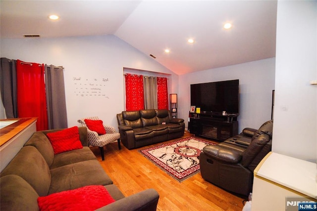 living room with recessed lighting, visible vents, light wood-style flooring, and vaulted ceiling