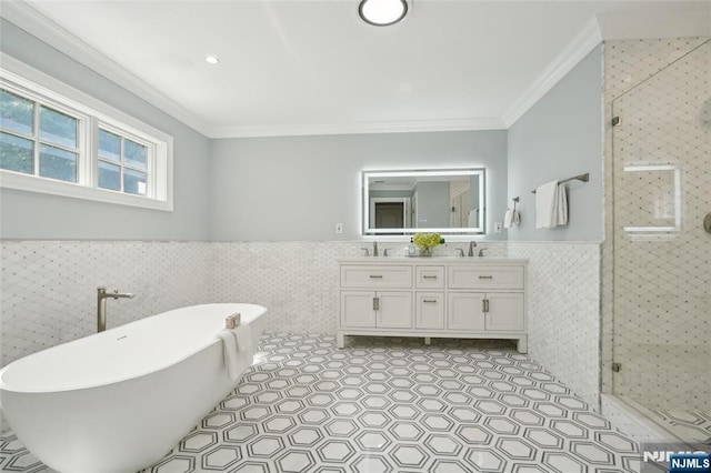 bathroom featuring tile patterned floors, a shower stall, ornamental molding, and wainscoting