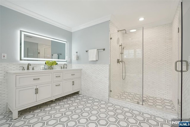 bathroom with wainscoting, tile walls, ornamental molding, and a shower stall