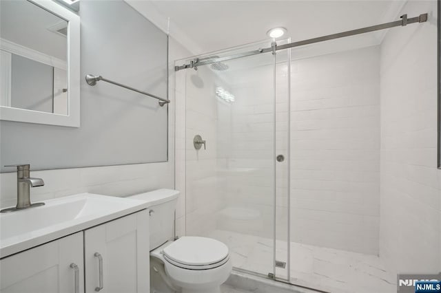 full bathroom featuring vanity, a shower stall, toilet, and tile walls