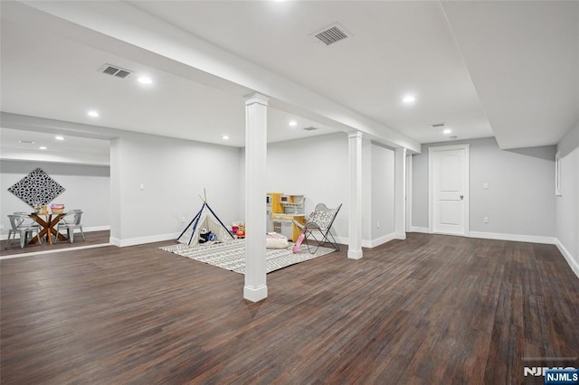 finished below grade area featuring dark wood finished floors, visible vents, and recessed lighting