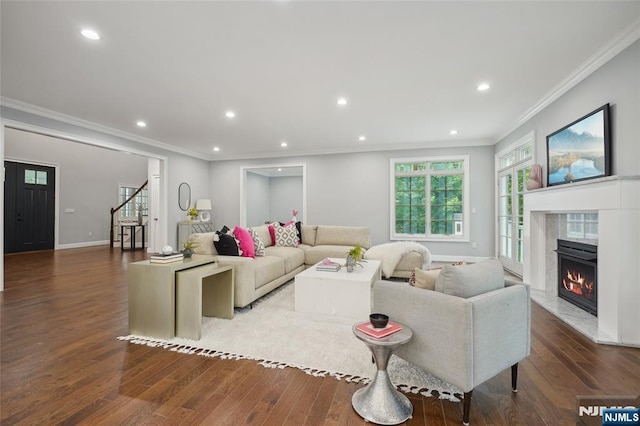 living room with baseboards, a premium fireplace, recessed lighting, ornamental molding, and hardwood / wood-style flooring