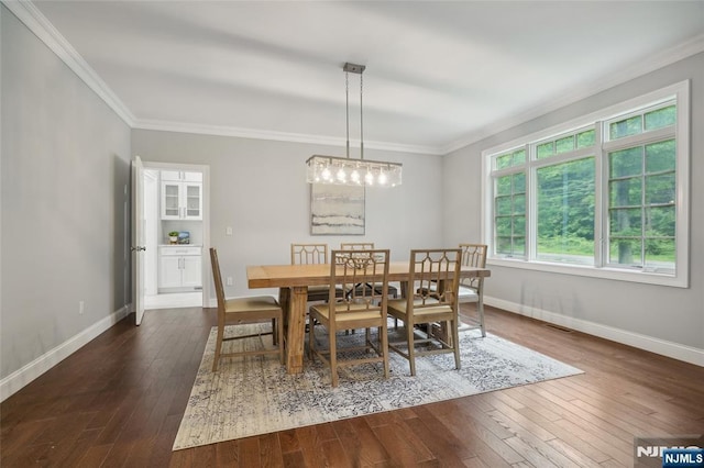 dining space with dark wood finished floors, baseboards, and ornamental molding