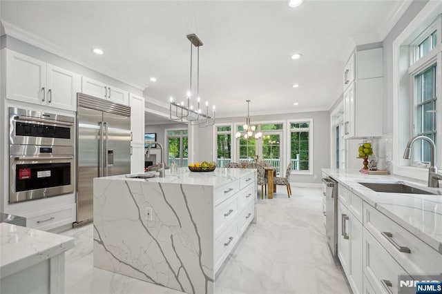 kitchen with ornamental molding, stainless steel appliances, marble finish floor, and a sink