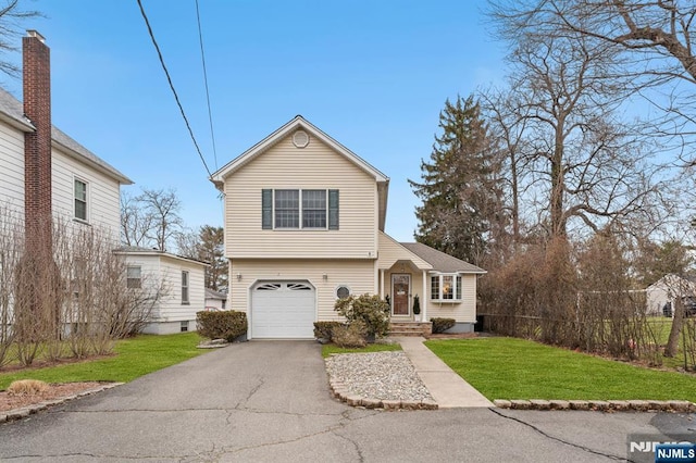 view of front of home with a garage, driveway, and a front yard