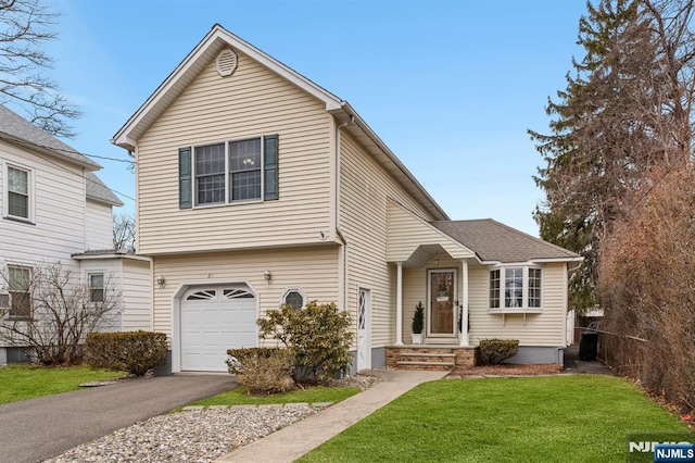 view of front of property featuring driveway, a front lawn, and an attached garage