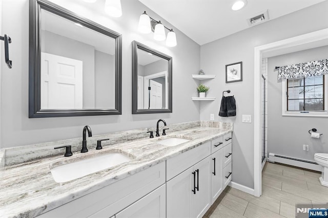 full bath featuring a baseboard heating unit, double vanity, a sink, and visible vents