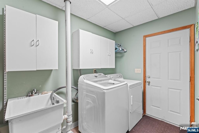 laundry room featuring washing machine and dryer, cabinet space, and a sink