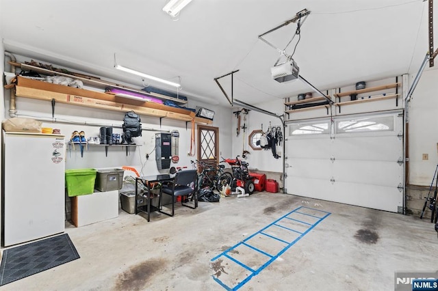 garage featuring freestanding refrigerator and a garage door opener