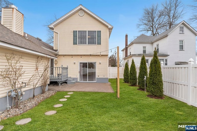 back of house with a patio area, a fenced backyard, and a lawn