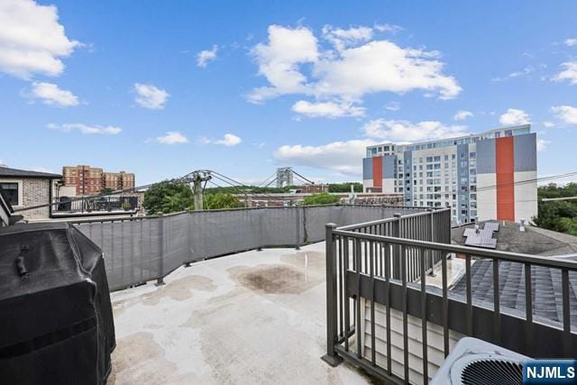 view of patio featuring a grill, a balcony, and central air condition unit