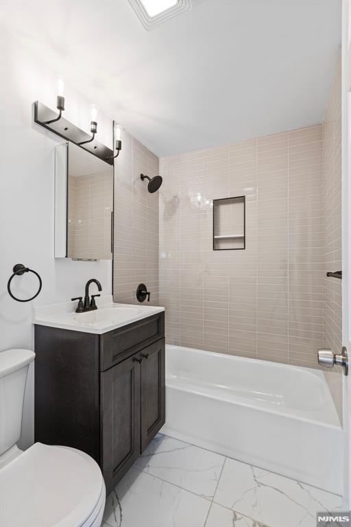 bathroom with shower / washtub combination, marble finish floor, toilet, and vanity