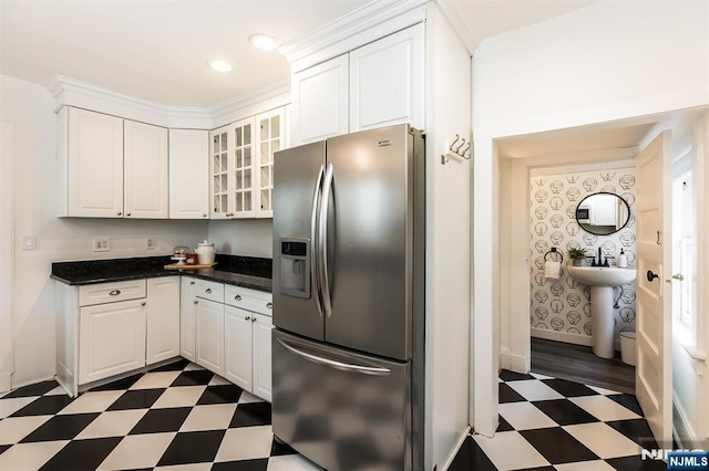 kitchen featuring white cabinetry, glass insert cabinets, stainless steel refrigerator with ice dispenser, and dark floors