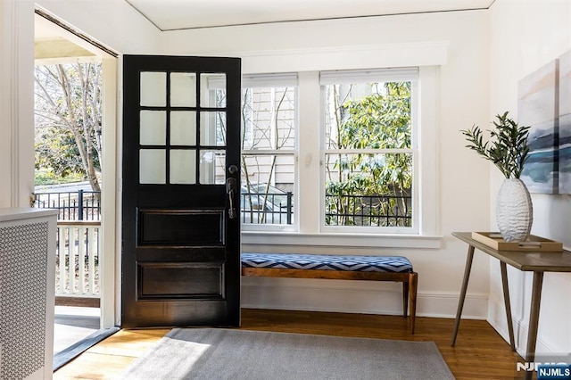 doorway with wood finished floors and baseboards