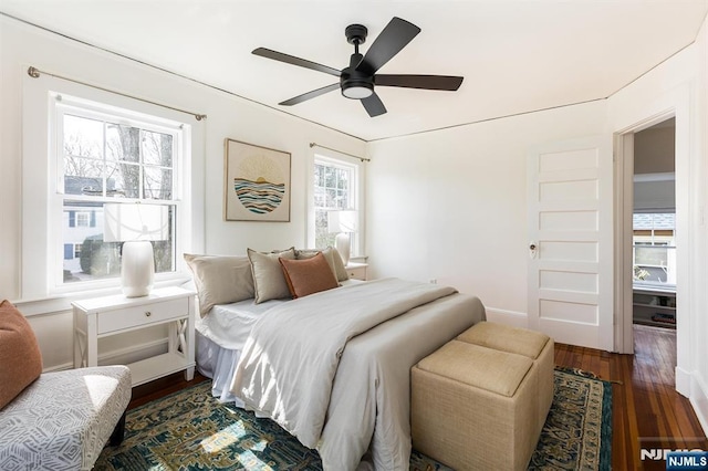 bedroom with baseboards, ceiling fan, and dark wood-style flooring