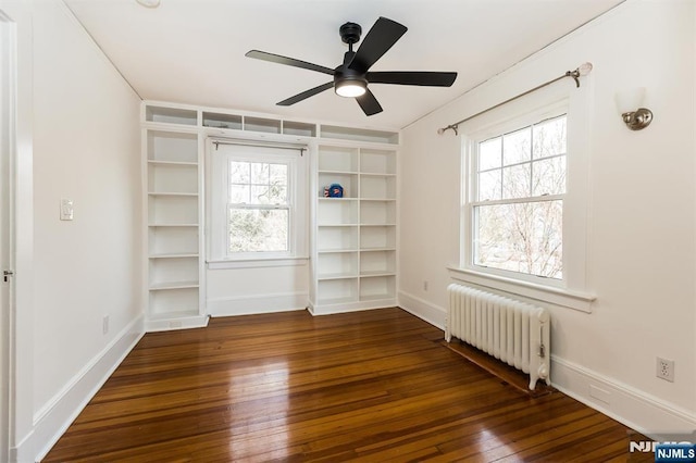 unfurnished room featuring baseboards, a ceiling fan, radiator heating unit, and hardwood / wood-style flooring