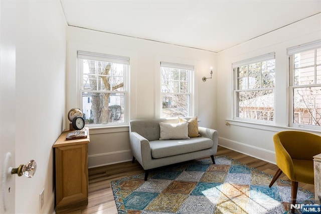 sitting room featuring plenty of natural light, wood finished floors, and baseboards