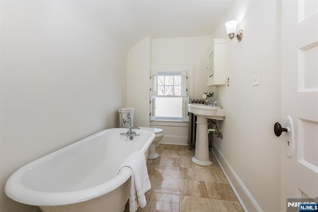 full bath featuring a soaking tub and baseboards