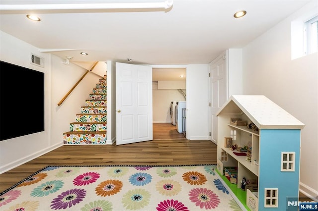 recreation room with washing machine and clothes dryer, visible vents, baseboards, recessed lighting, and wood finished floors