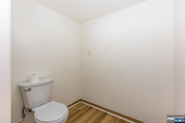 bathroom featuring toilet, wood finished floors, and baseboards