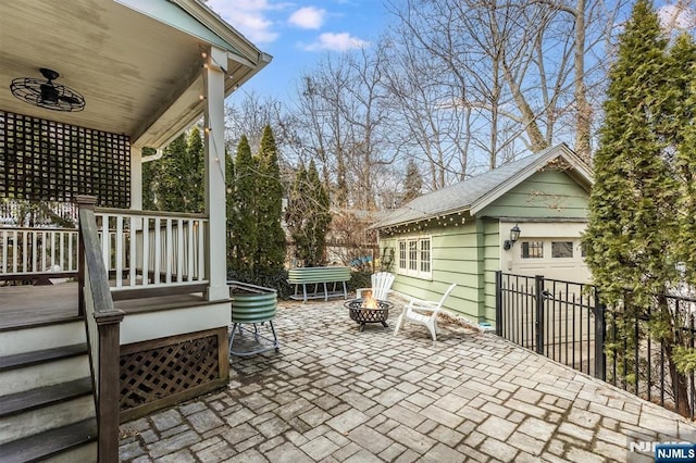 view of patio with an outbuilding, a fire pit, and fence