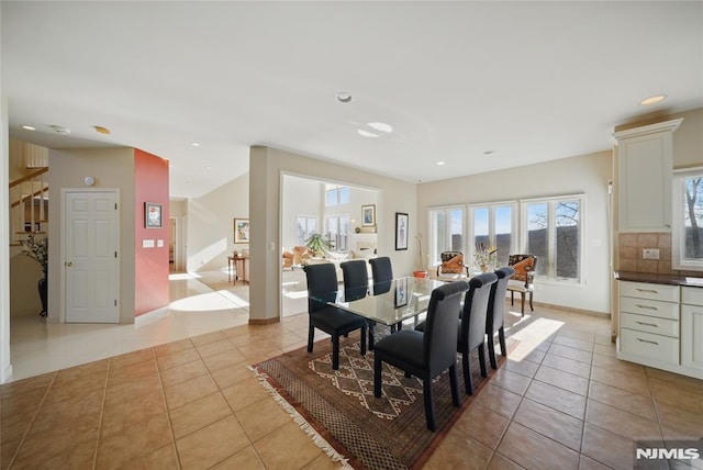 dining area featuring stairs, light tile patterned flooring, recessed lighting, and baseboards