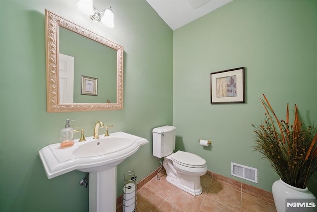 half bathroom featuring tile patterned flooring, toilet, baseboards, and visible vents