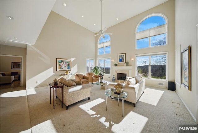 living room featuring recessed lighting, a healthy amount of sunlight, a high end fireplace, and carpet floors