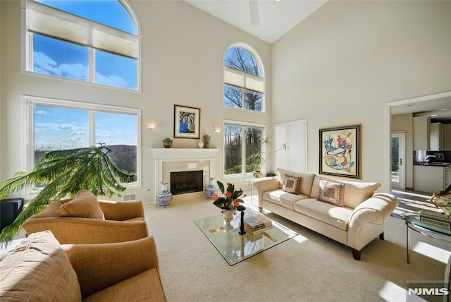 carpeted living room with plenty of natural light, a fireplace, visible vents, and vaulted ceiling