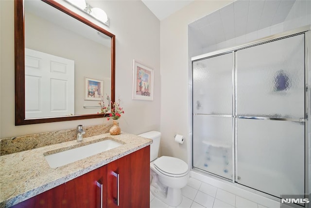 bathroom with toilet, a stall shower, vanity, and tile patterned flooring