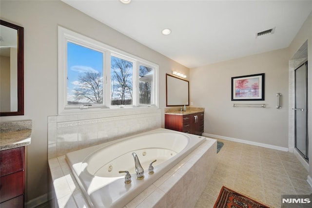 bathroom featuring visible vents, a jetted tub, a shower stall, baseboards, and vanity