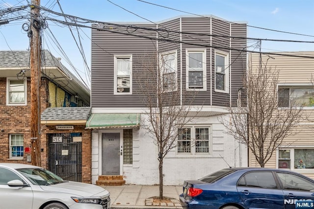 townhome / multi-family property featuring brick siding and entry steps