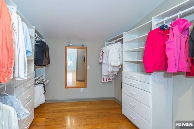 walk in closet with light wood-style floors