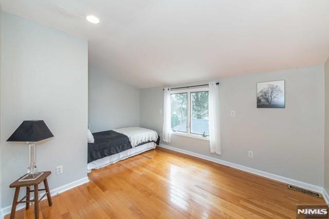 bedroom with light wood finished floors, visible vents, recessed lighting, and baseboards