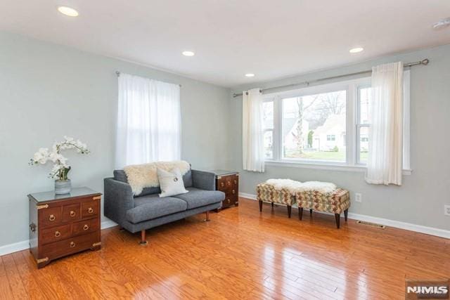 living area with recessed lighting, baseboards, and light wood finished floors