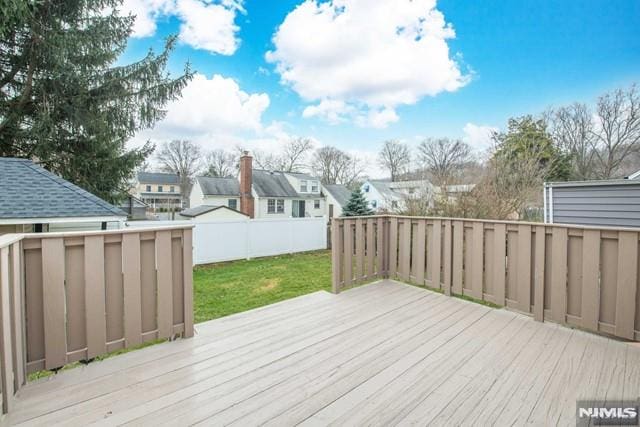 wooden deck featuring a yard, fence, and a residential view