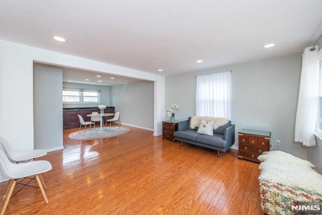 living room with recessed lighting, baseboards, and wood finished floors