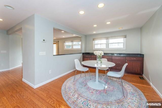 dining space with light wood-style flooring, recessed lighting, and baseboards