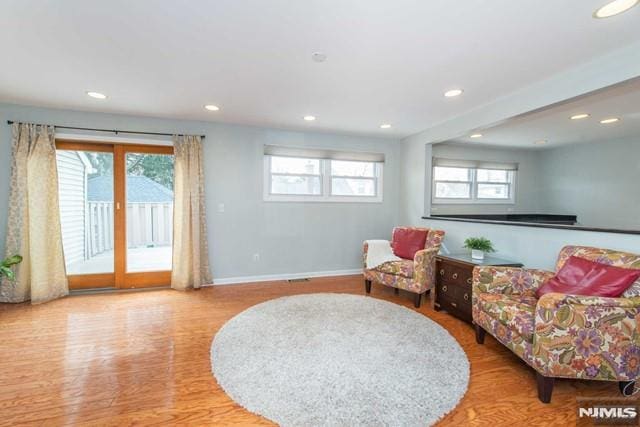 living area featuring wood finished floors, recessed lighting, baseboards, and a wealth of natural light