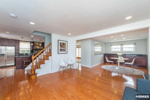 living area featuring stairway, recessed lighting, baseboards, and wood finished floors