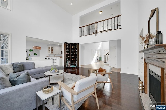 living area with stairway, wood finished floors, visible vents, baseboards, and a high end fireplace