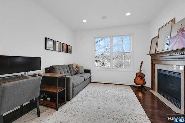 living room featuring recessed lighting, a fireplace, baseboards, and wood finished floors