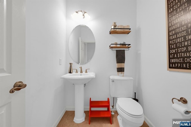 bathroom with toilet and baseboards