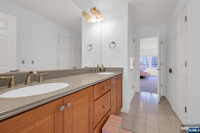 bathroom featuring a sink, ensuite bath, double vanity, and tile patterned flooring