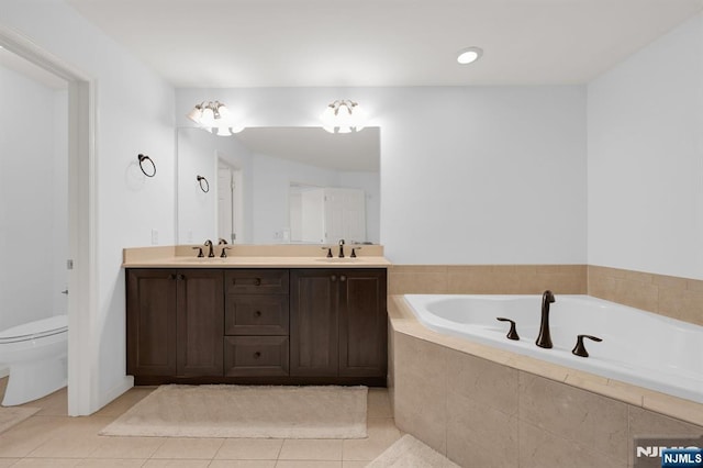 bathroom with tile patterned flooring, a garden tub, double vanity, and a sink