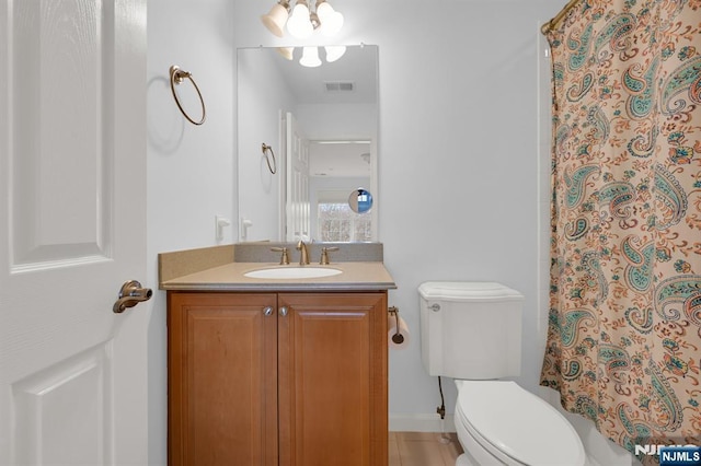 bathroom with a shower with shower curtain, toilet, vanity, and visible vents