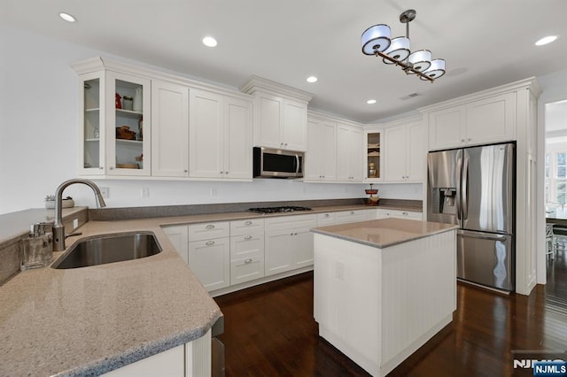 kitchen featuring dark wood finished floors, white cabinets, appliances with stainless steel finishes, and a sink