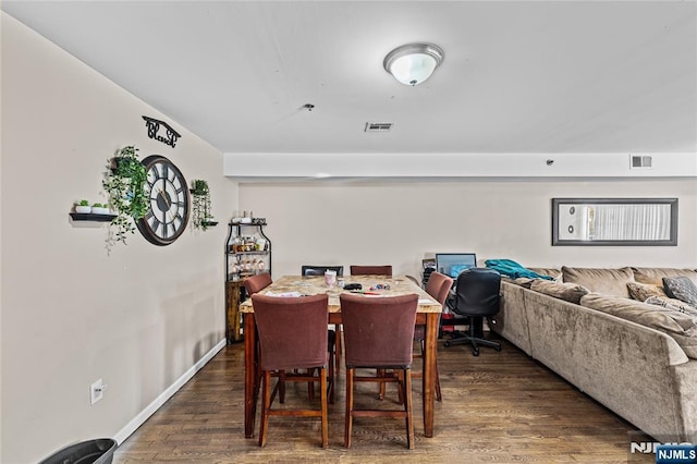 dining space with visible vents, baseboards, and wood finished floors