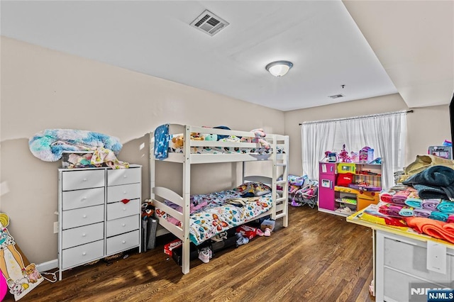 bedroom with visible vents and wood finished floors