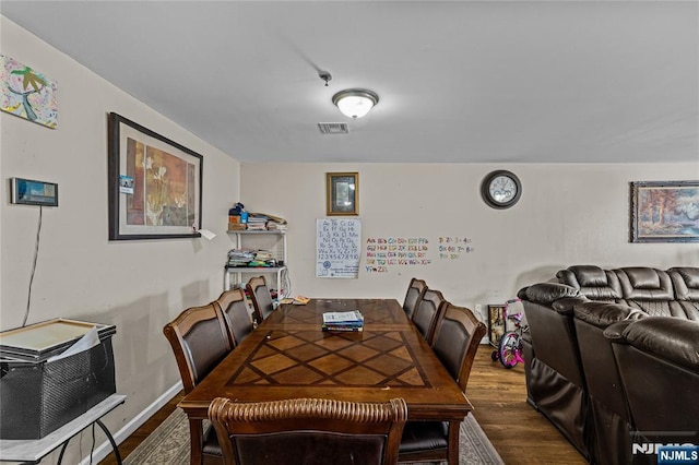 dining space with visible vents, baseboards, and wood finished floors